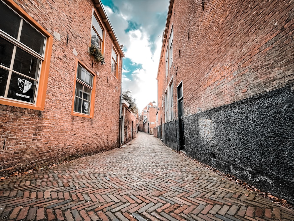 a narrow brick street with a window on the side
