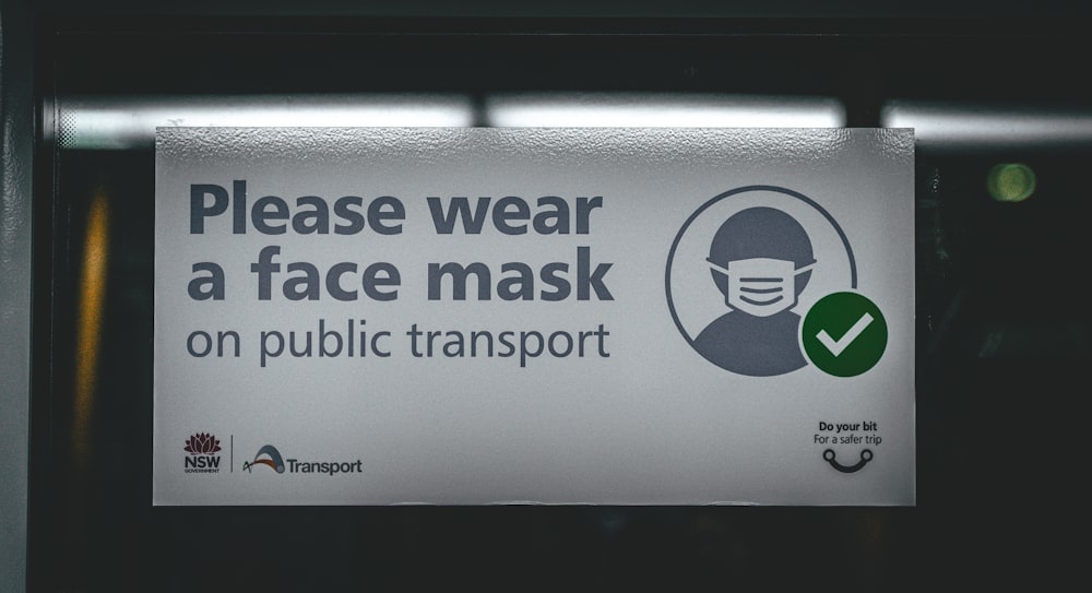 a sign on a public transportation bus warning people to wear a face mask