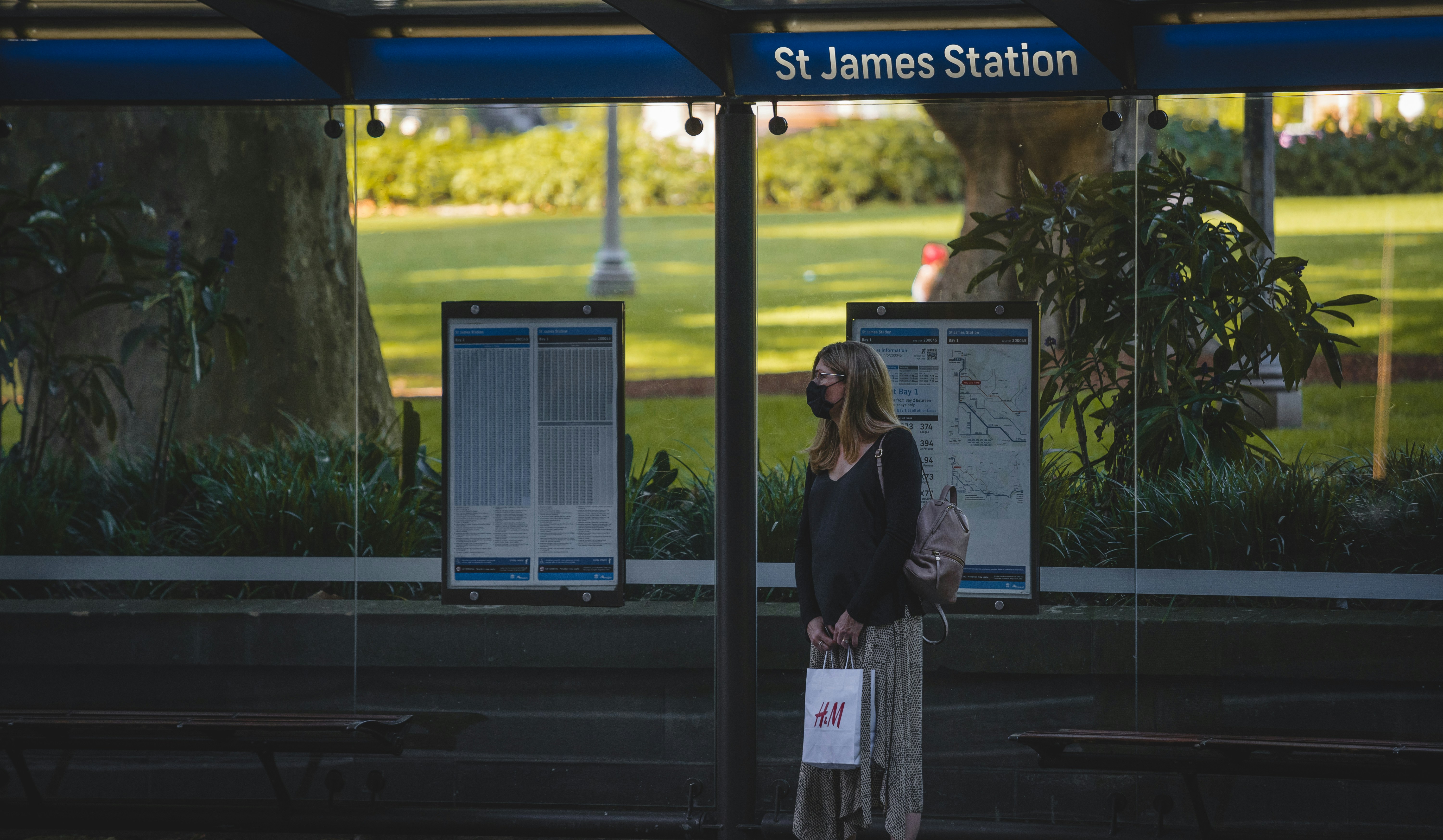 a woman standing in front of a bus stop