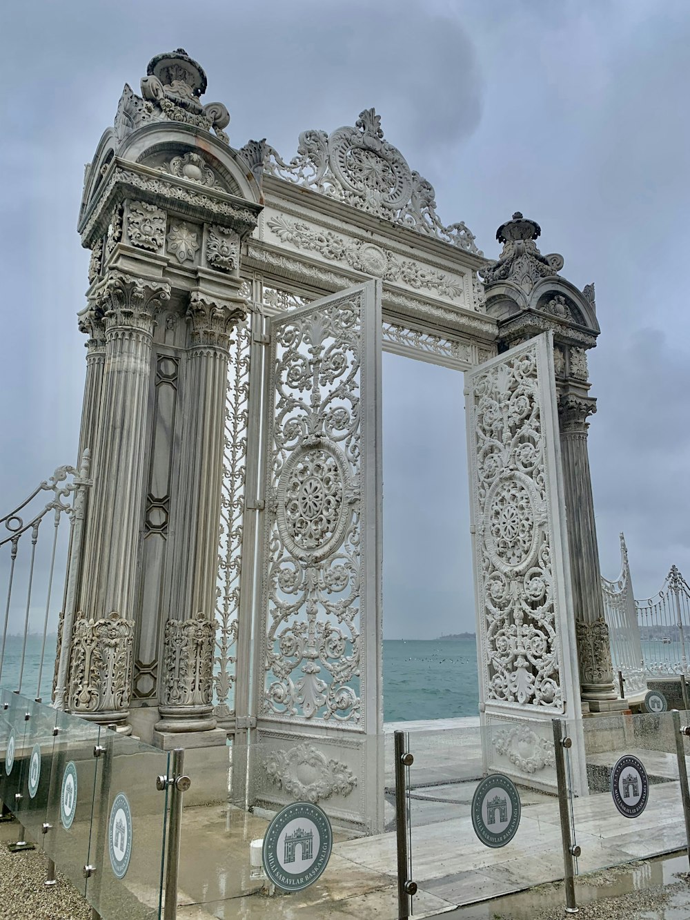 a large white gate sitting next to the ocean