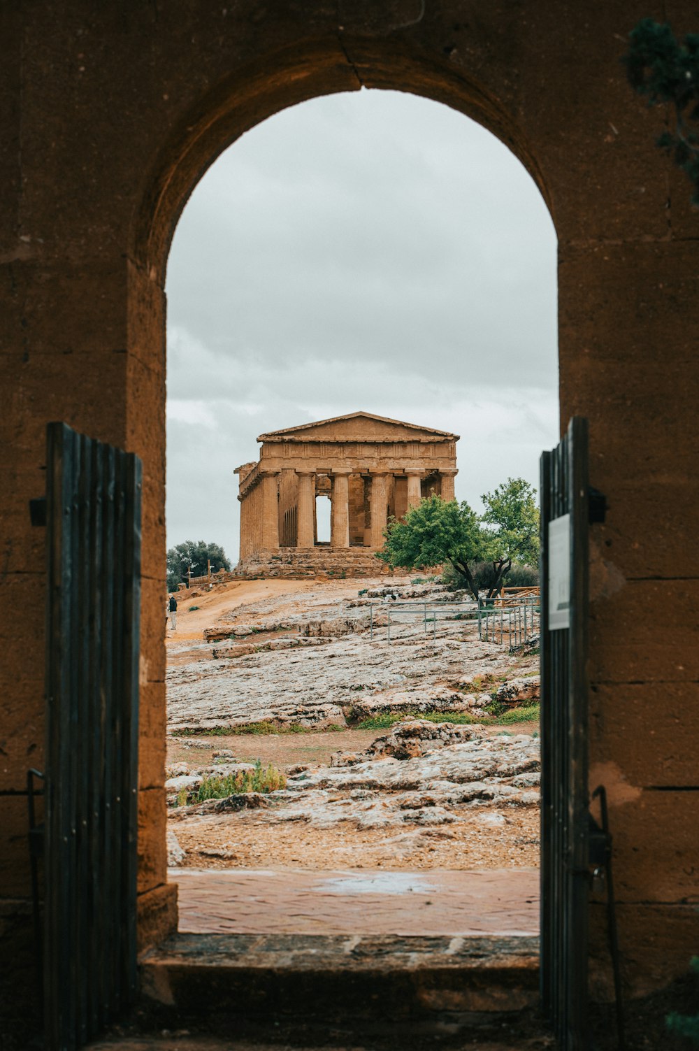 an arch leading to a building on a hill