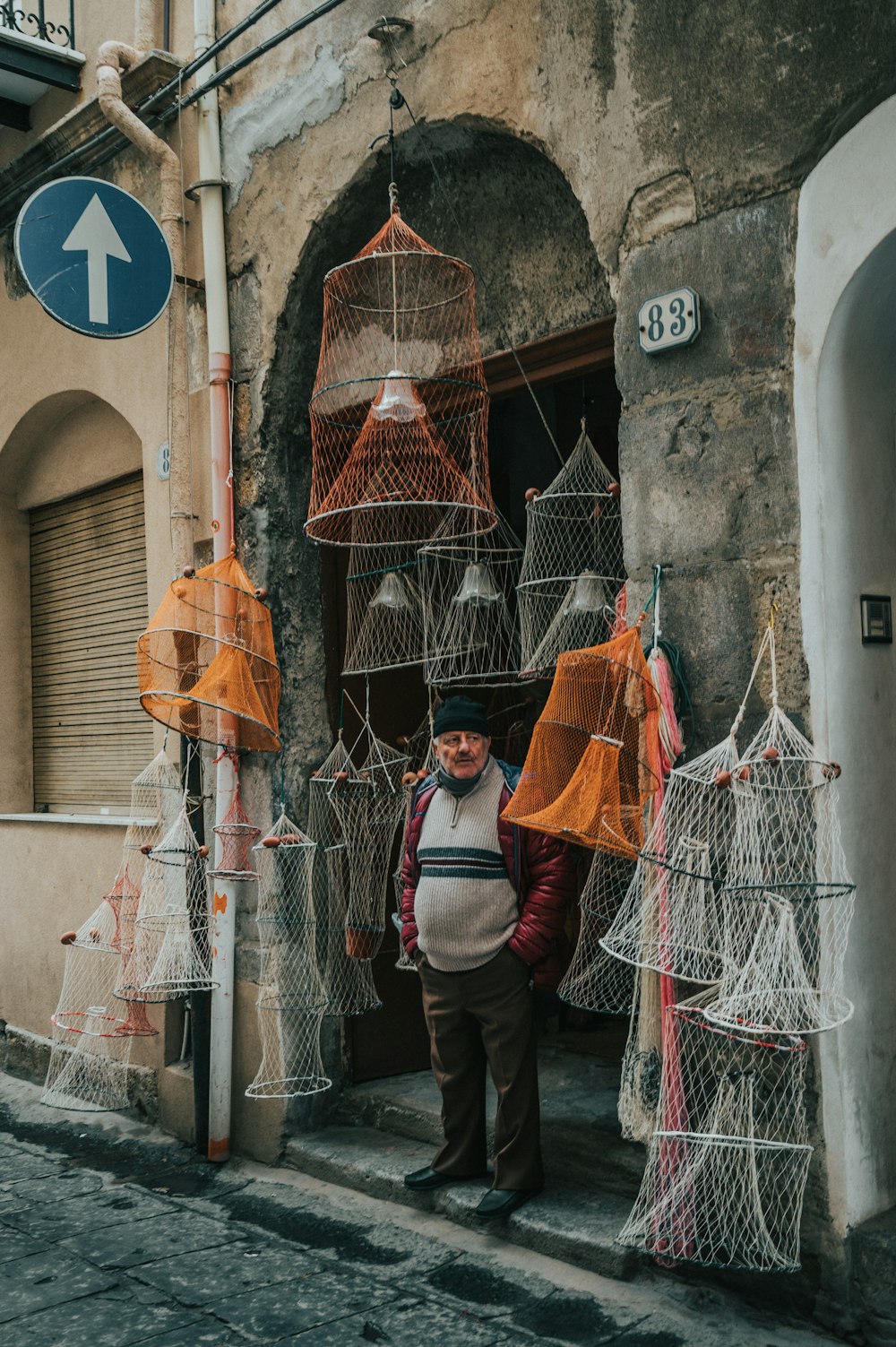 a man standing in front of a building with lots of bird cages