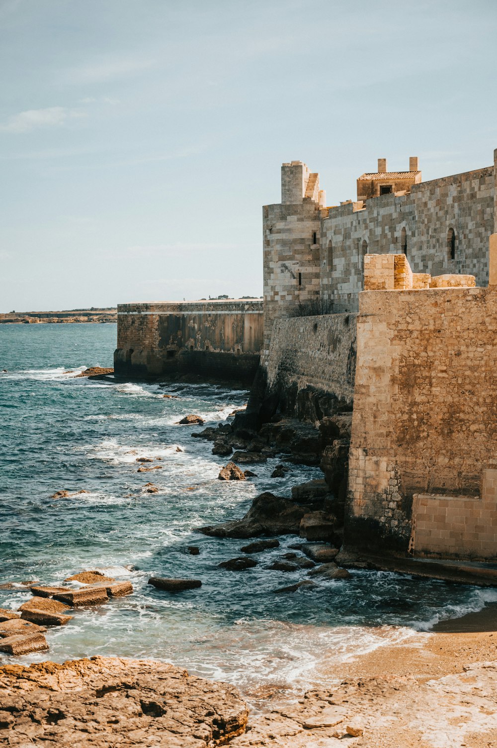 a stone wall next to a body of water