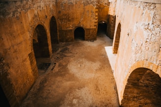 An elegant monochrome shot of ancient stone arches bathed in gentle bronze light