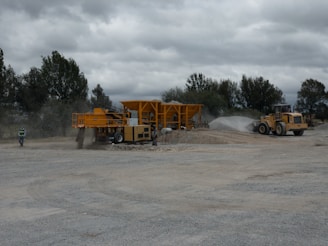 A large construction site with heavy machinery moving gravel and sand.