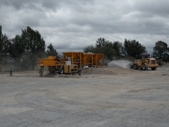 Instructor guiding workers through heavy equipment safety procedures on a sunny training site.
