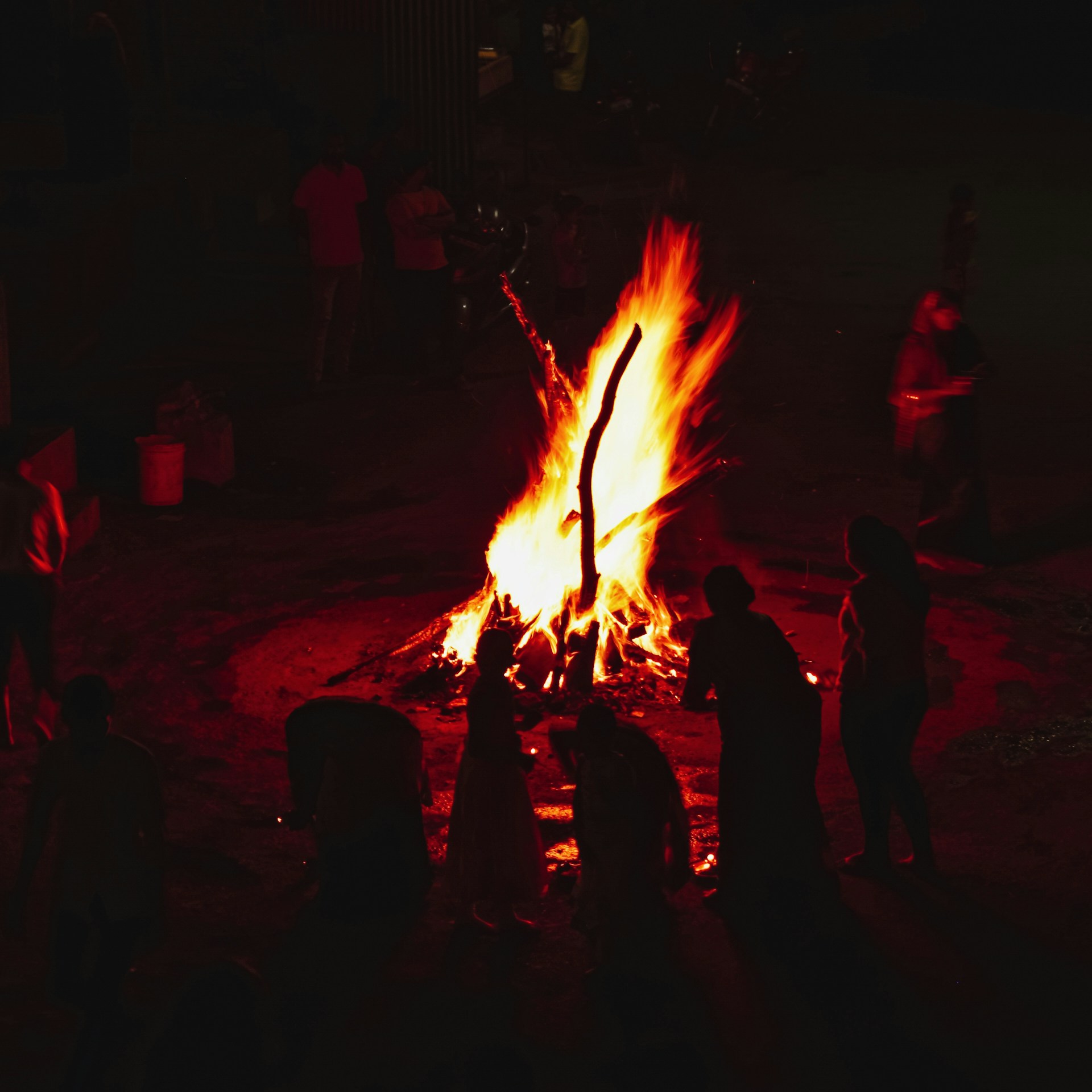 a group of people standing around a fire pit