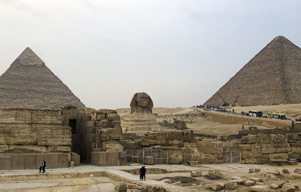 a group of people standing in front of two pyramids