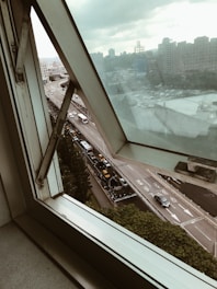 View from a hotel window overlooking a bustling city street.