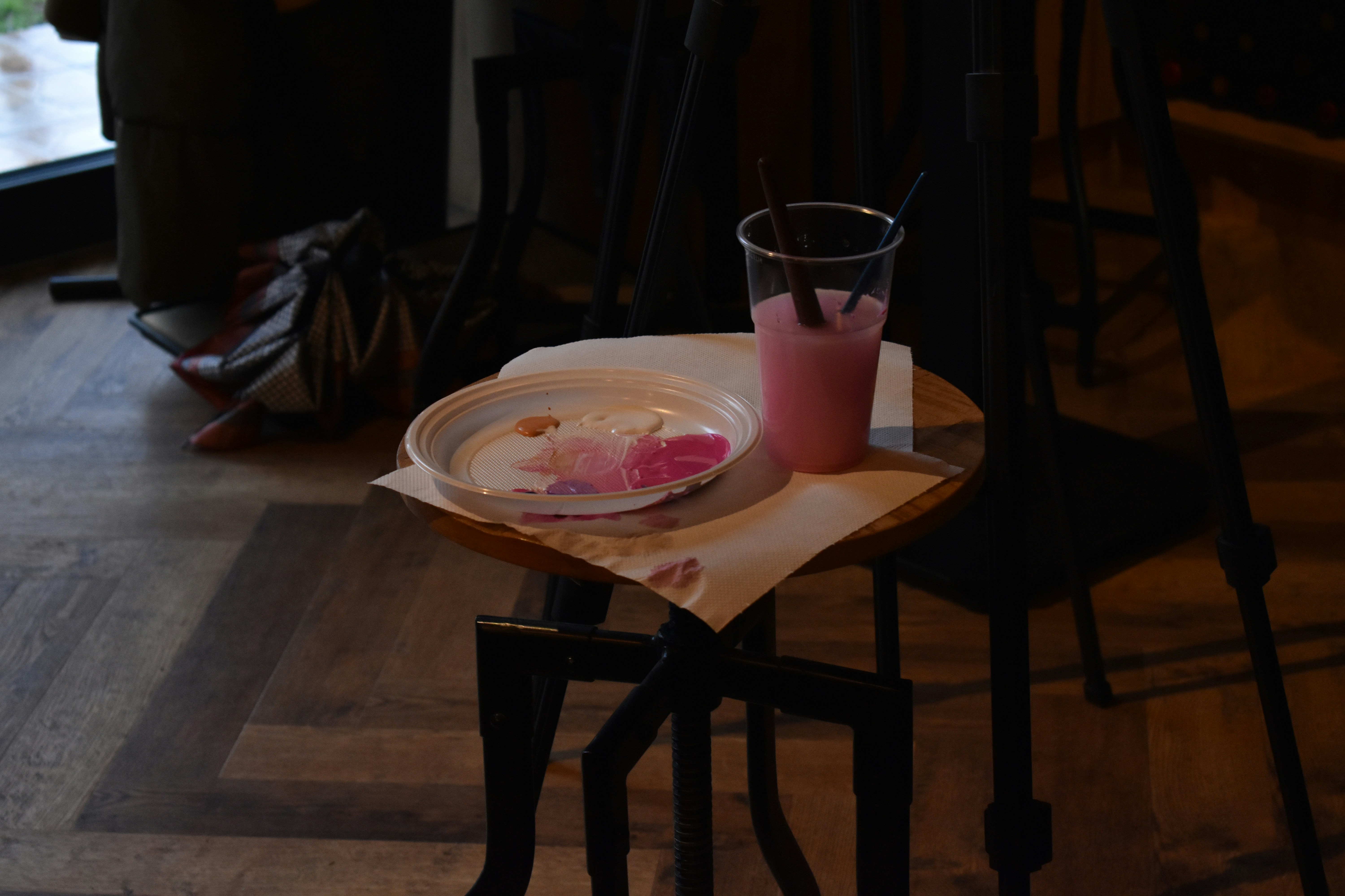 A pink drink and a plate with remnants of dessert.