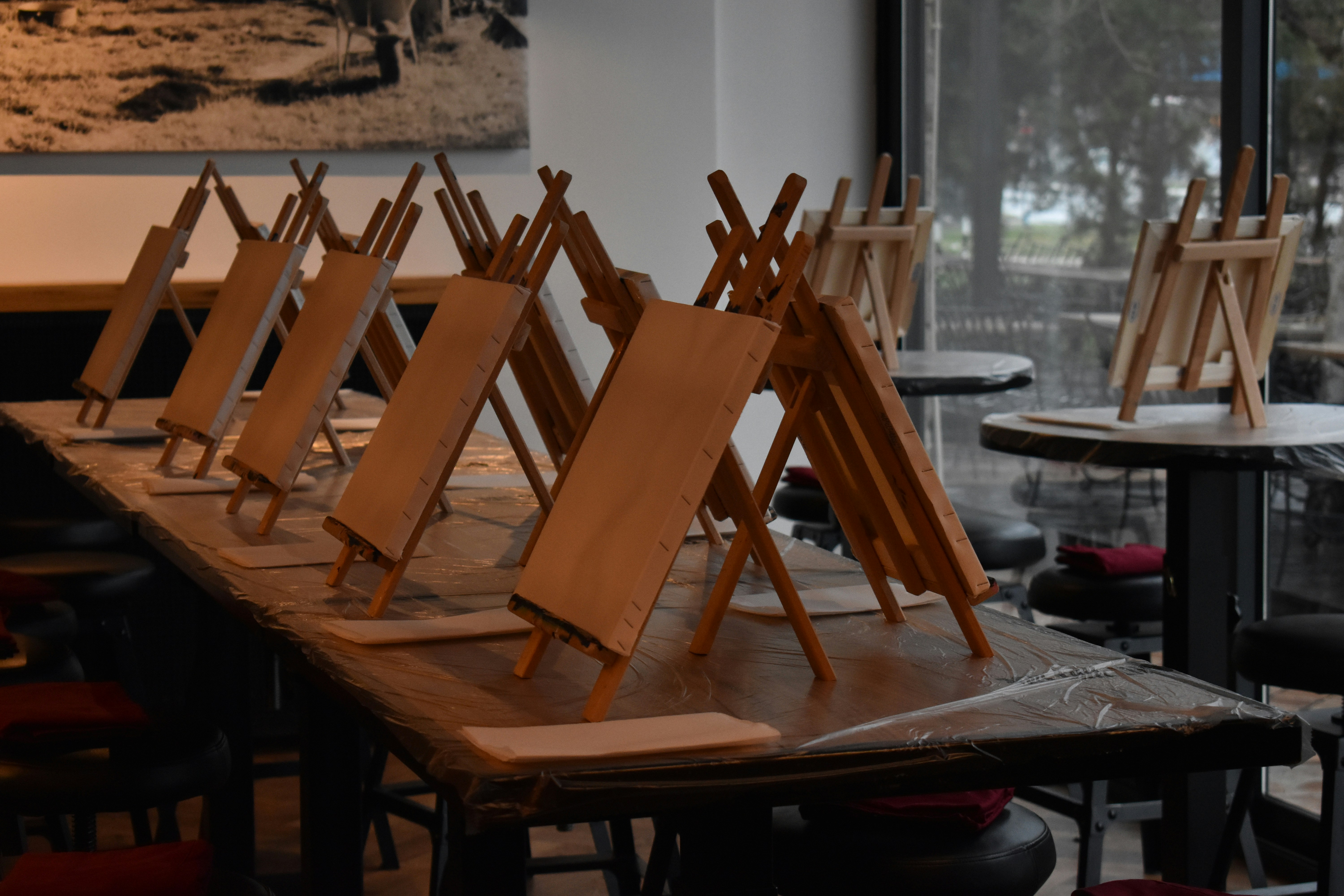 Wooden easels set up on a long table.
