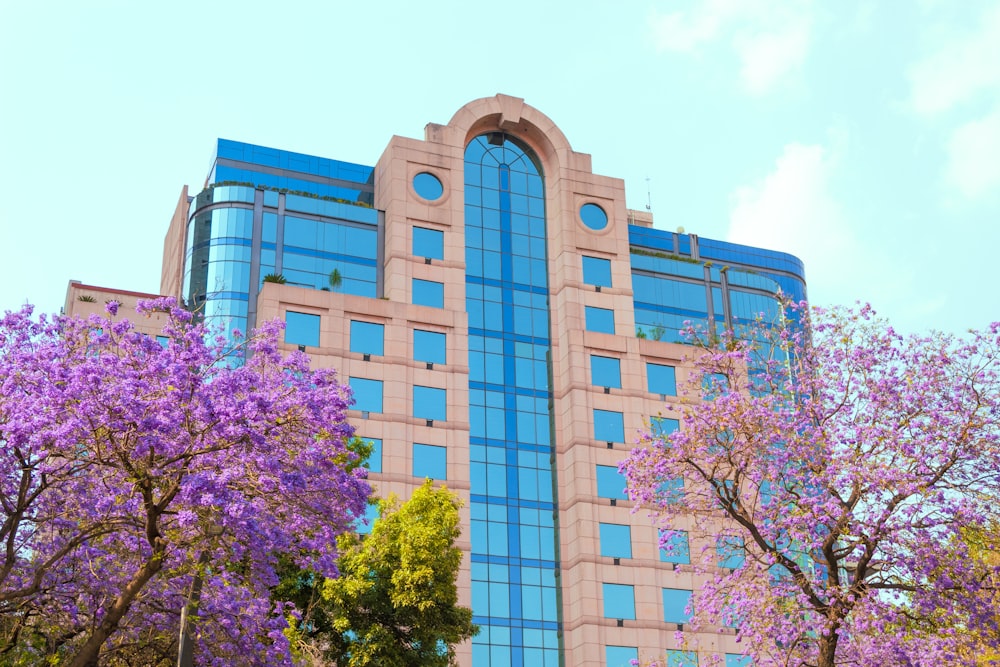 a tall building with a lot of windows and trees in front of it