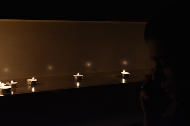 A softly glowing candle casting shadows during a late-night psychic session.