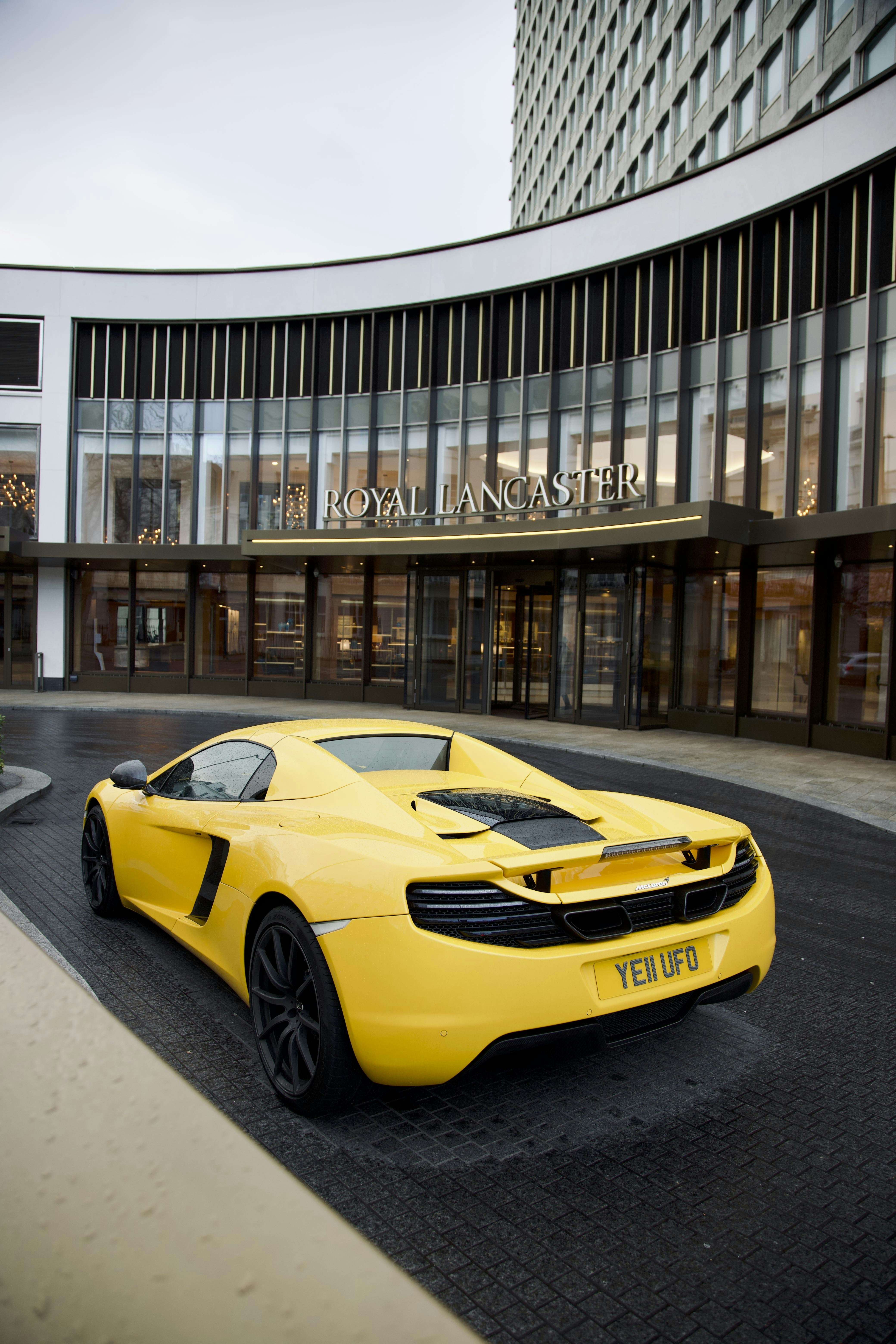 une voiture de sport jaune garée devant un immeuble