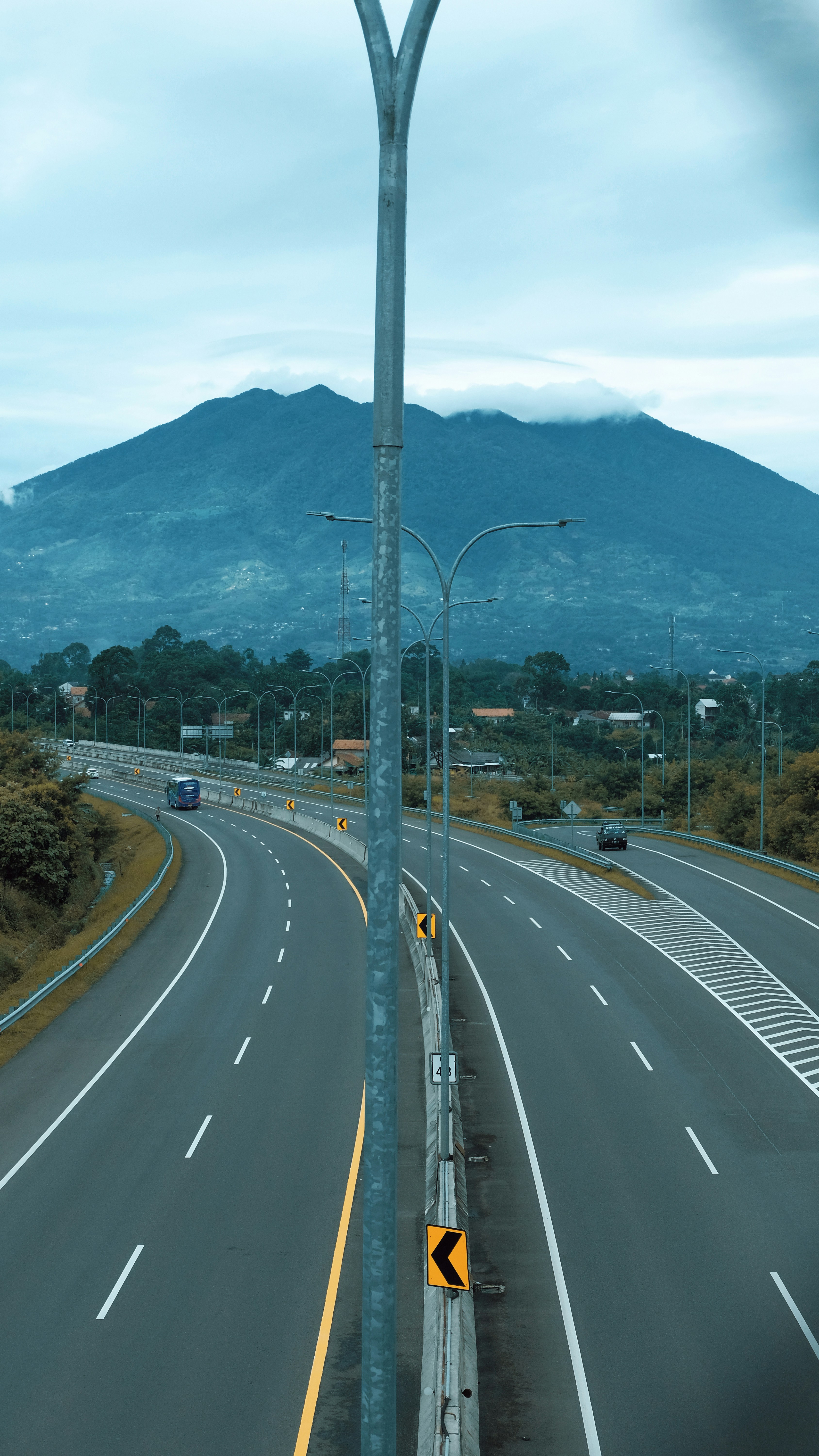 jalan raya kosong dengan gunung di latar belakang