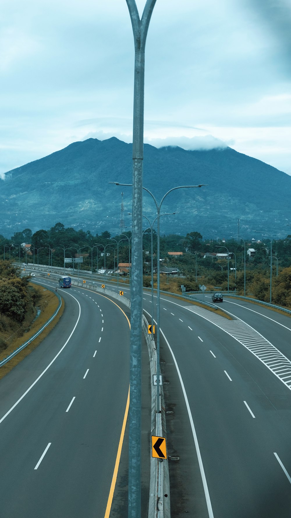 an empty highway with a mountain in the background