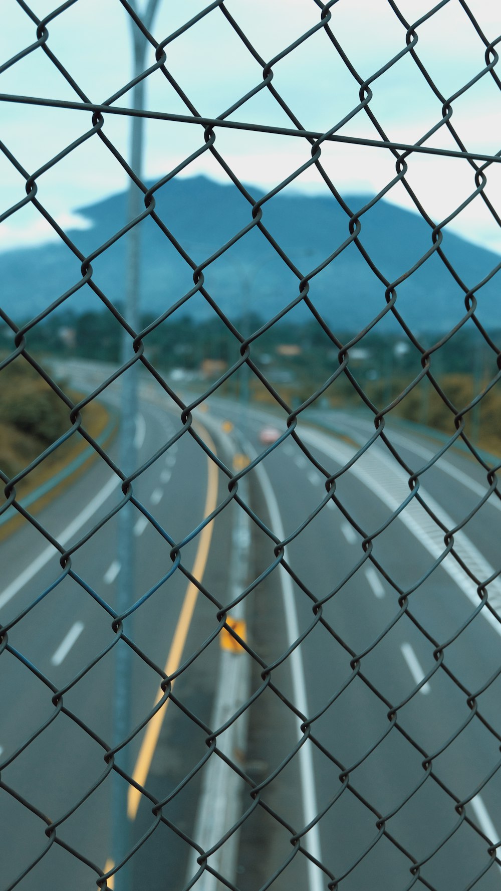 a view of a highway through a chain link fence