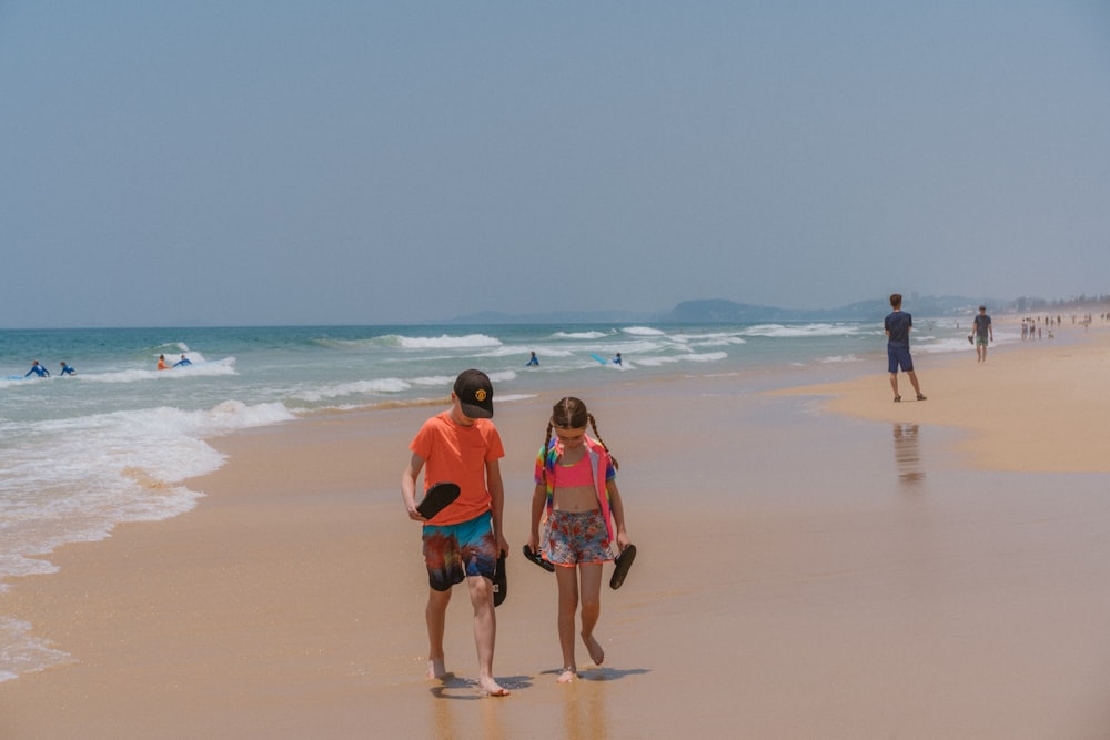 a man and a little girl standing on a beach
