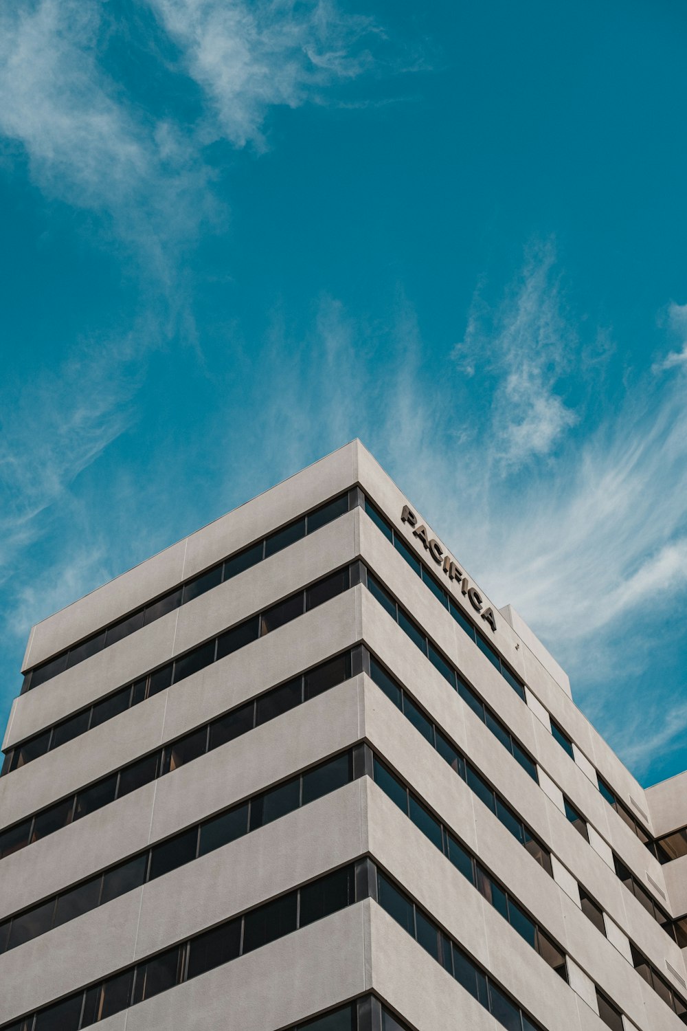 a tall white building sitting under a blue sky