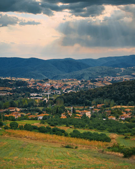 a view of a town in the distance with mountains in the background