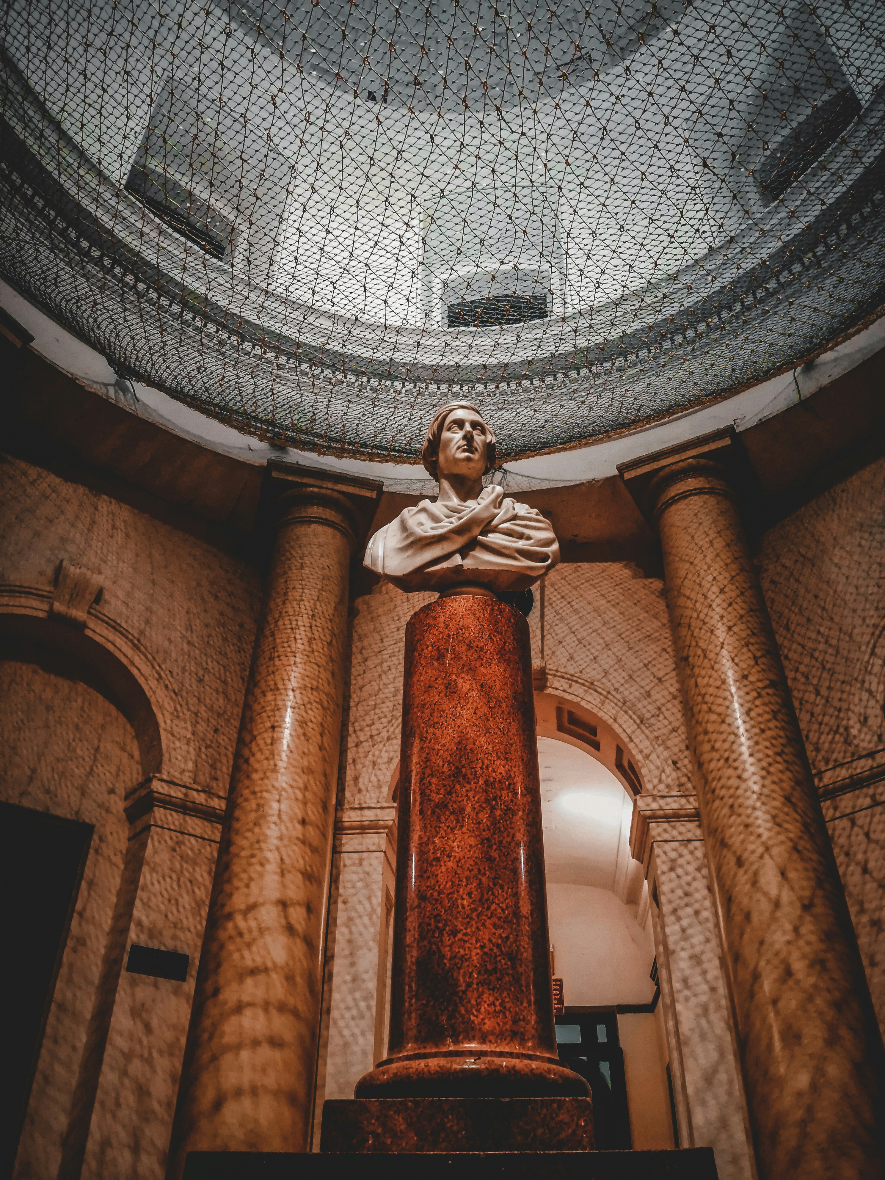 a statue of a man sitting on top of a pillar
