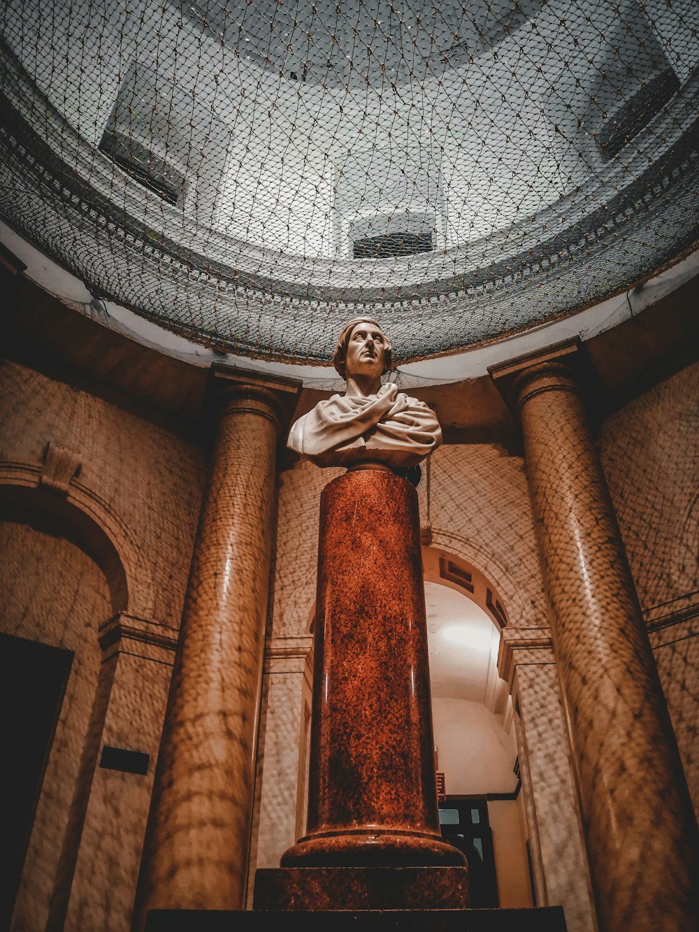 a statue of a man sitting on top of a pillar