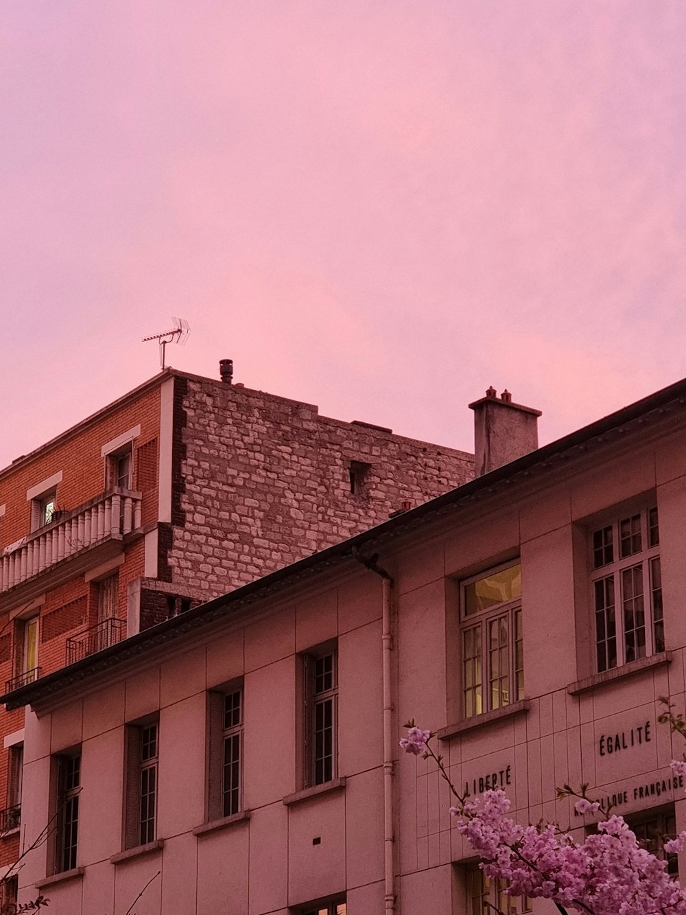 a building with a pink sky in the background