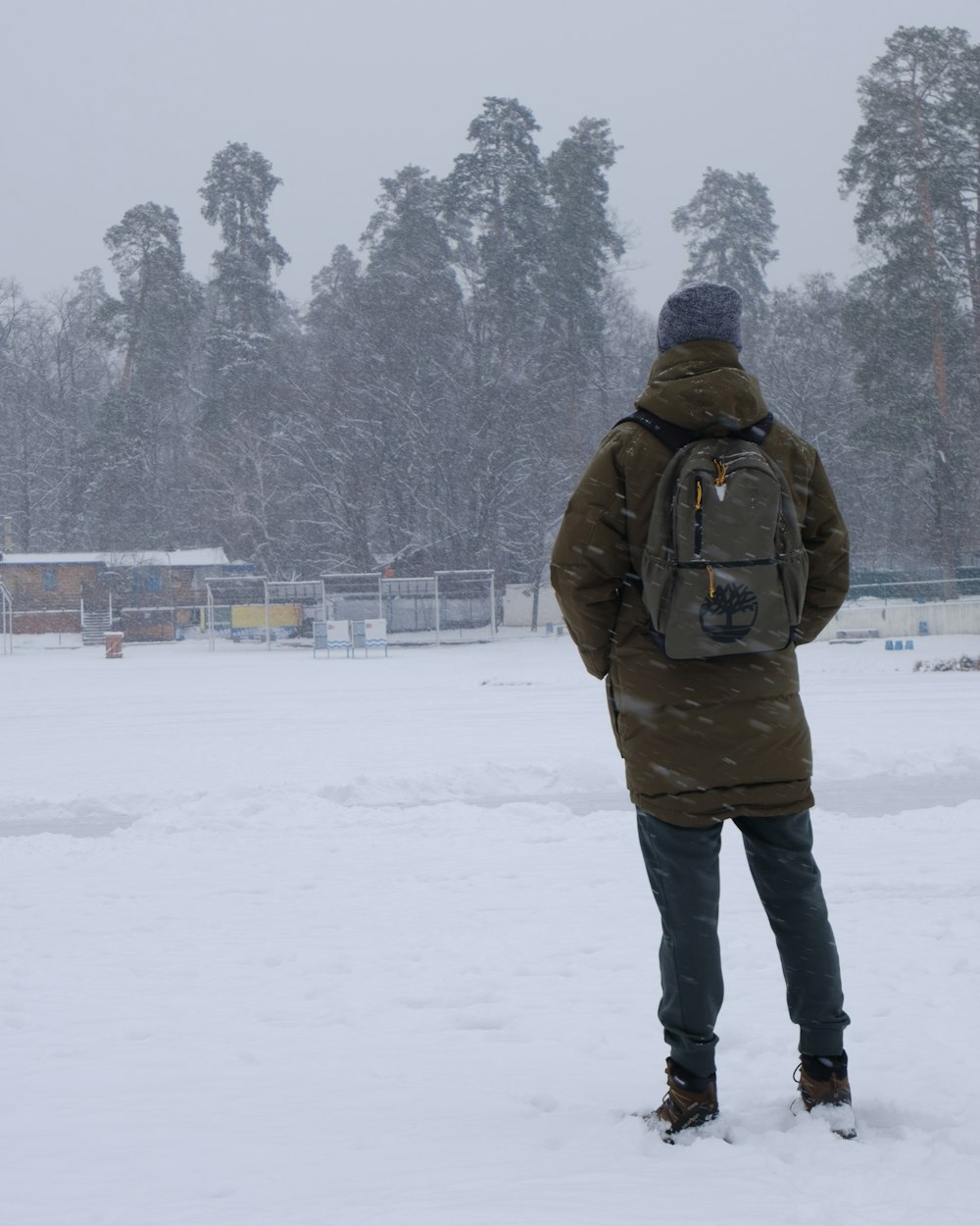 une personne debout dans la neige avec un sac à dos