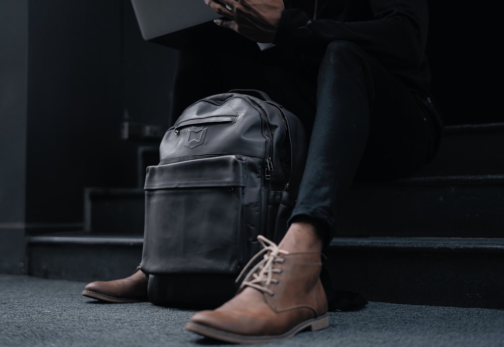 a person sitting on the steps with a laptop