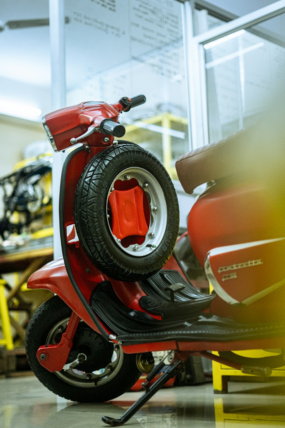 a red scooter is parked in a garage