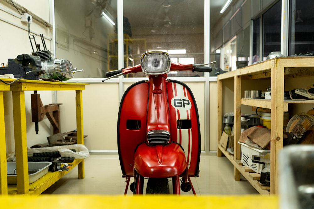a red scooter is parked in a garage