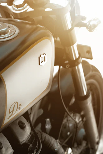 A lineup of synthetic oil containers highlighted by professional lighting, with an adventure motorcycle faintly visible behind.