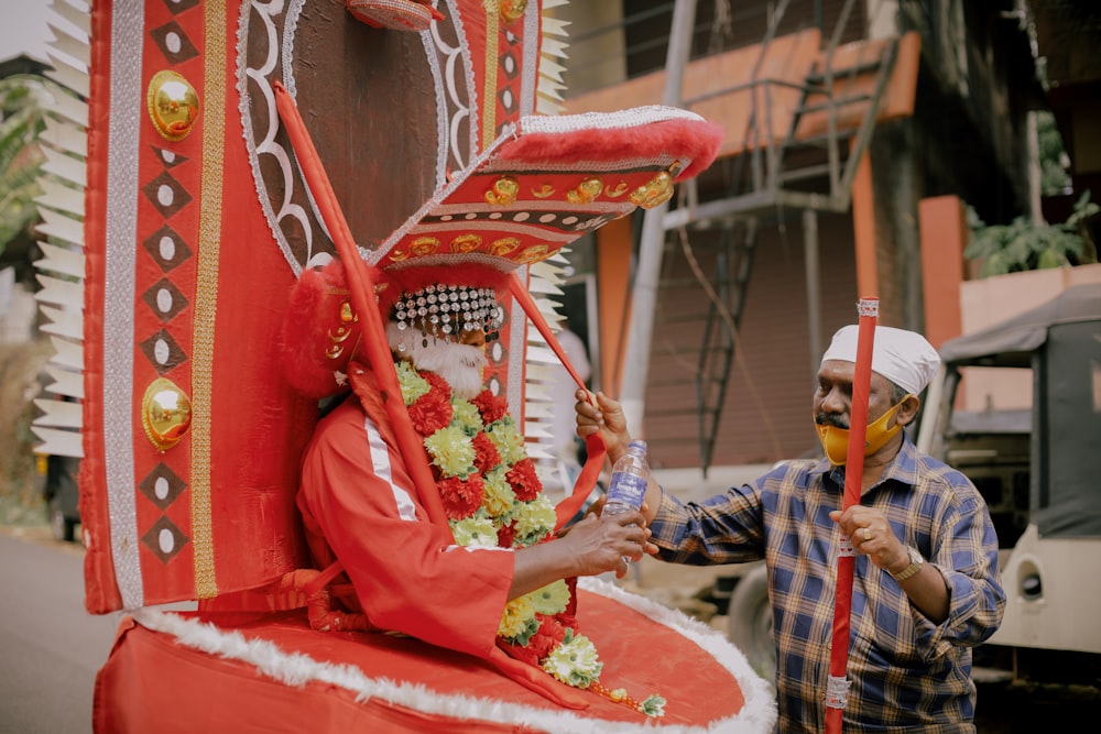 a man standing next to a float with a man in a mask on it