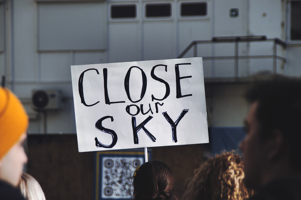 a close up of a sign with a sky background