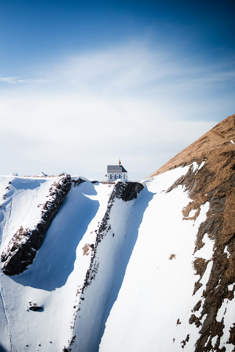 a house on top of a mountain covered in snow