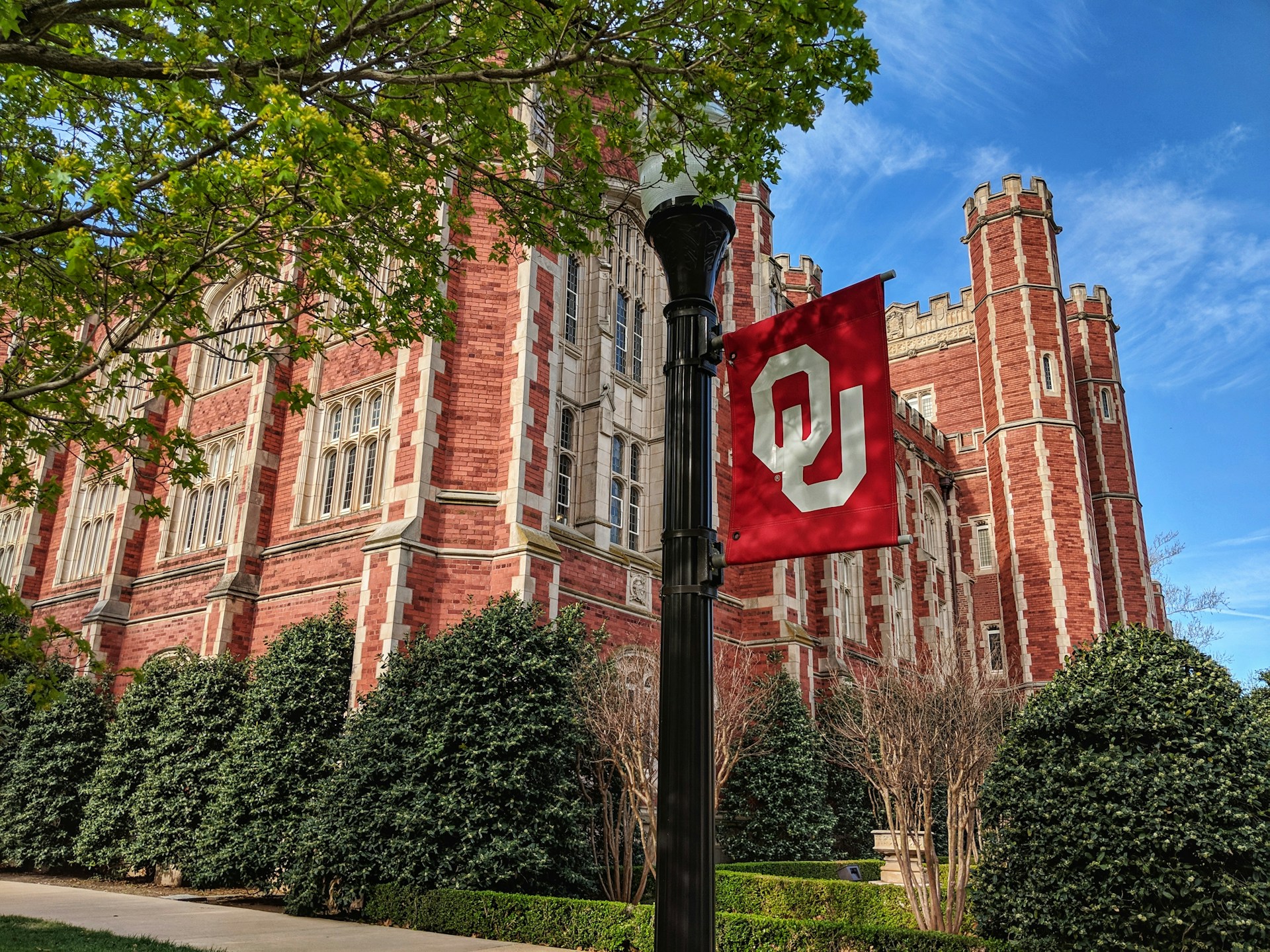 a red and white flag on a pole in front of a building