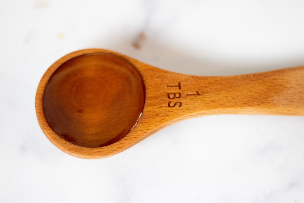 a wooden spoon with a measuring tape on it