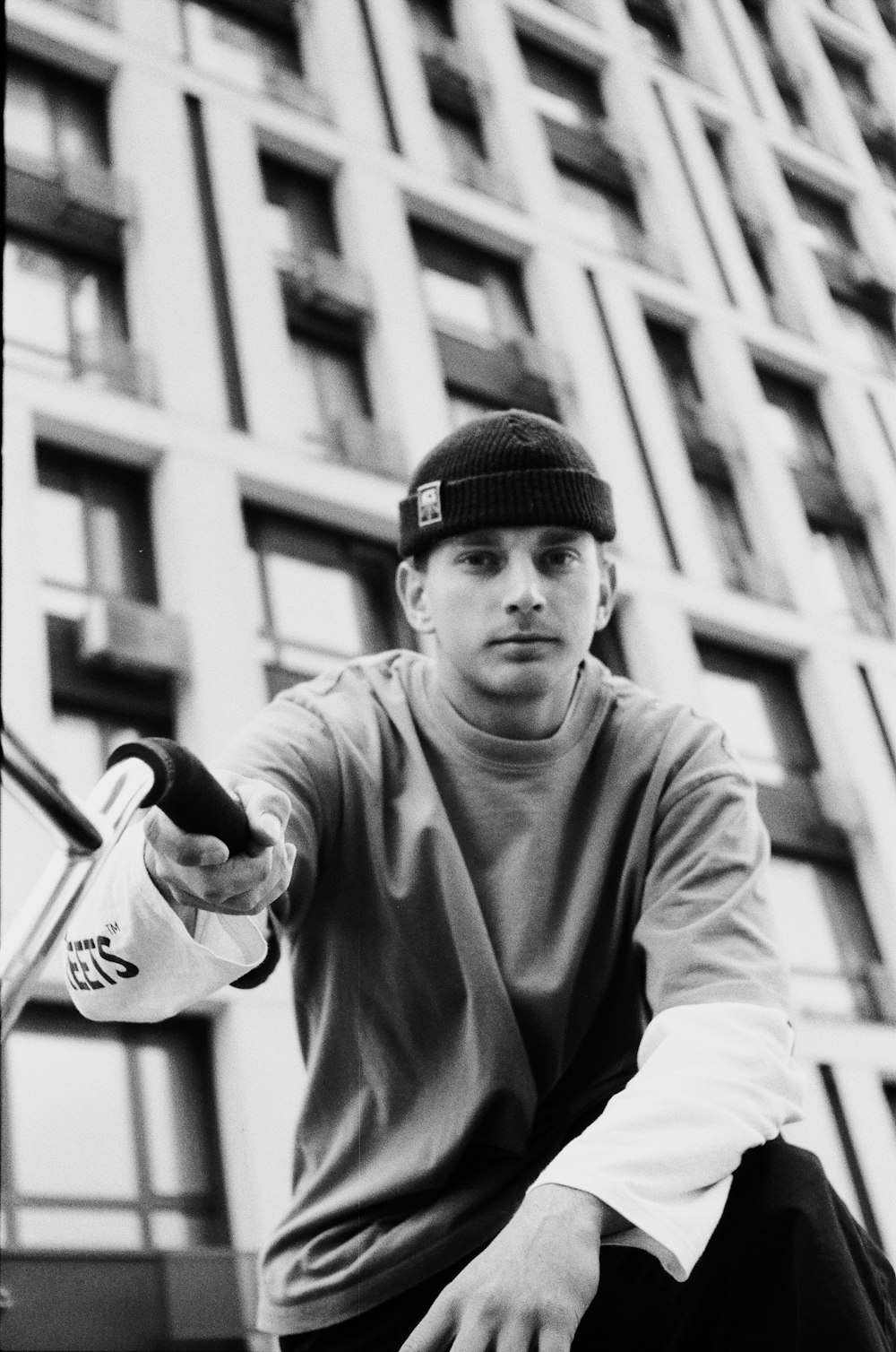 a black and white photo of a man holding a skateboard