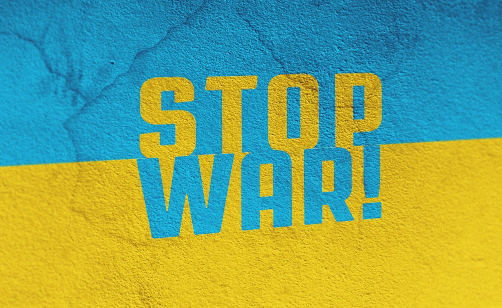 Una pared azul y amarilla con las palabras Stop War pintadas en ella