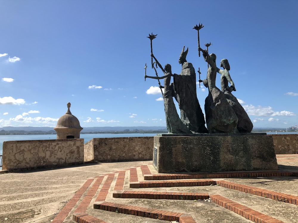 a statue of a group of people sitting on top of a rock