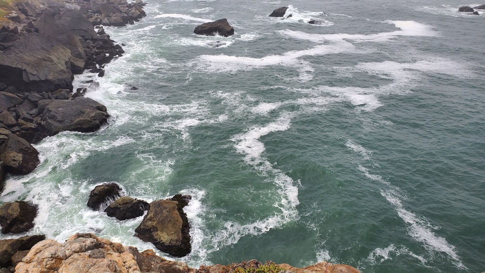 a view of a body of water with rocks in the foreground