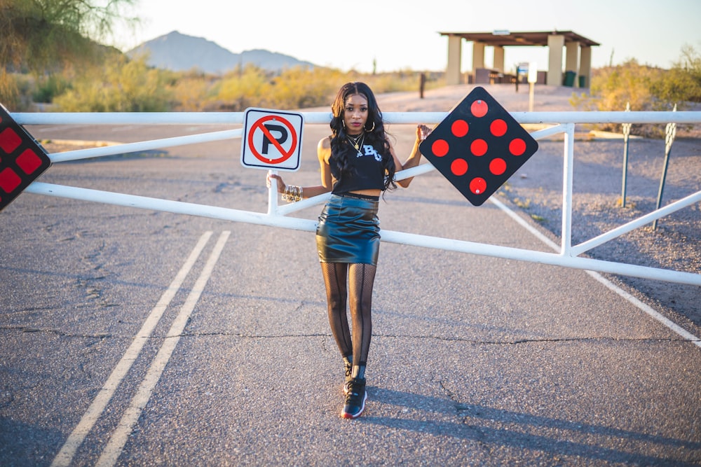 a woman holding a sign that says no parking