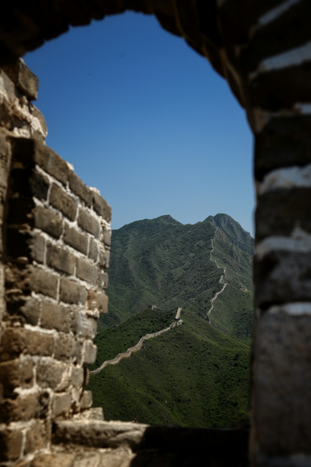 Blick durch ein Fenster auf die Chinesische Mauer