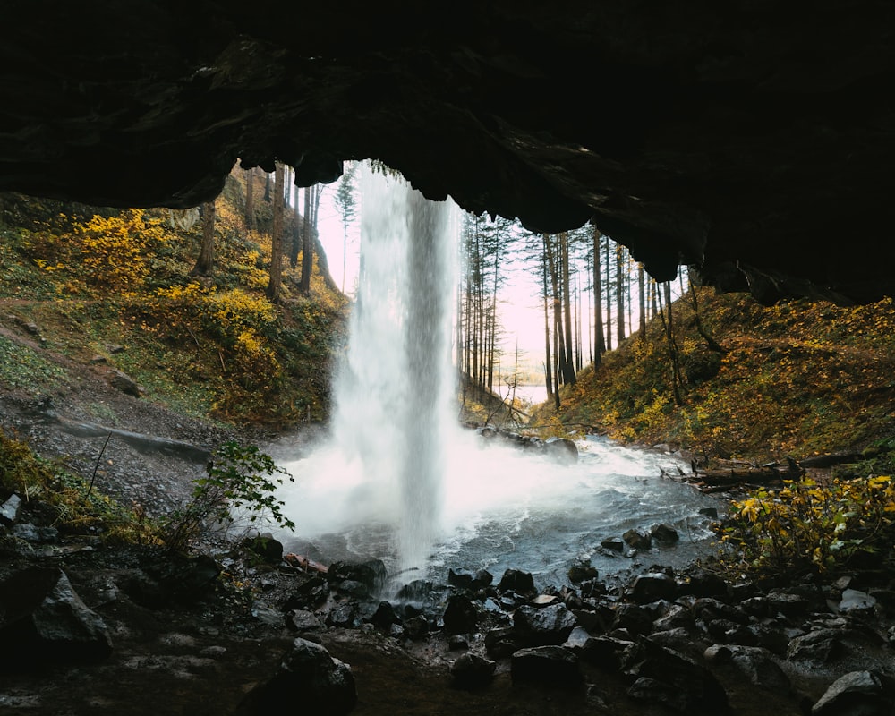a waterfall is coming out of a cave