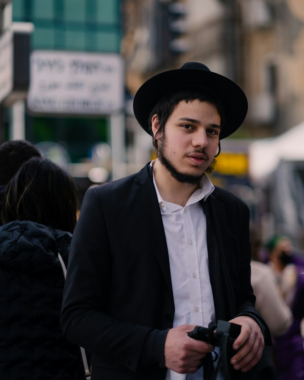 a man in a black hat is holding a camera