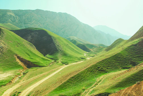 a scenic view of a valley with mountains in the background