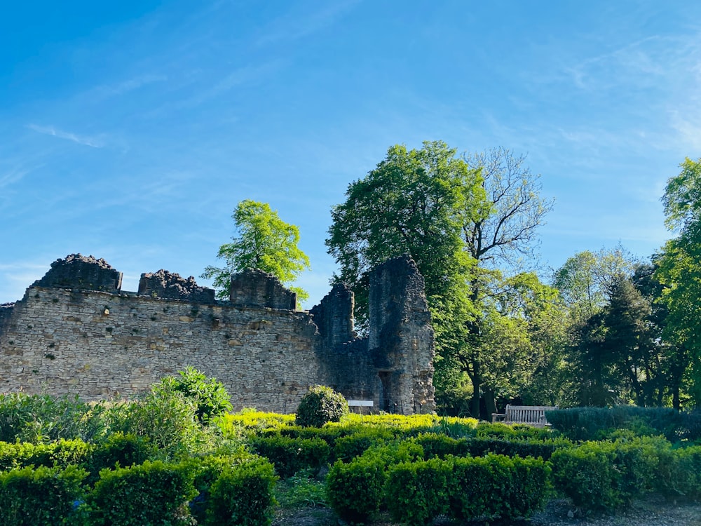 a stone castle surrounded by trees and bushes