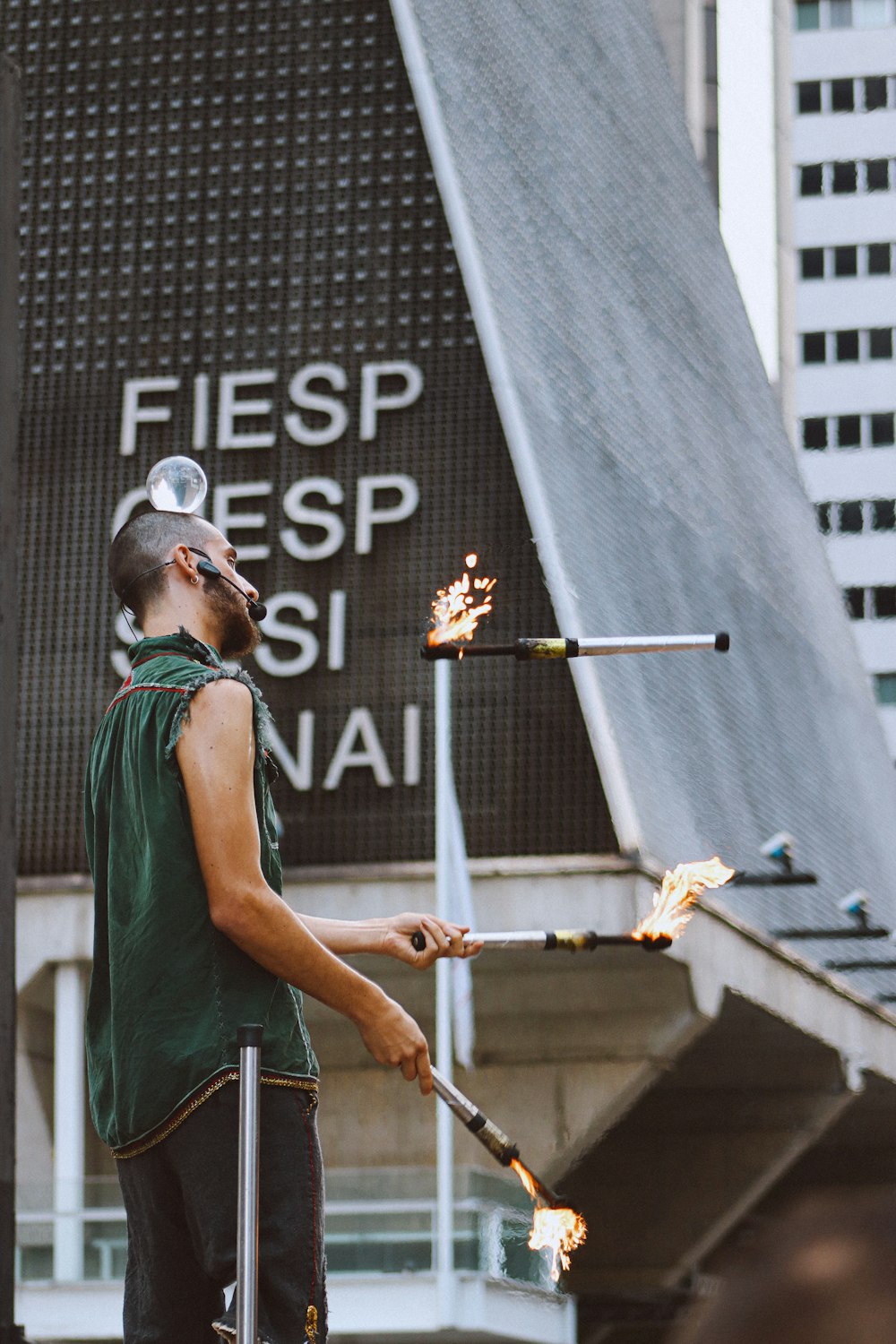 a man with a beard and a green shirt is holding torches