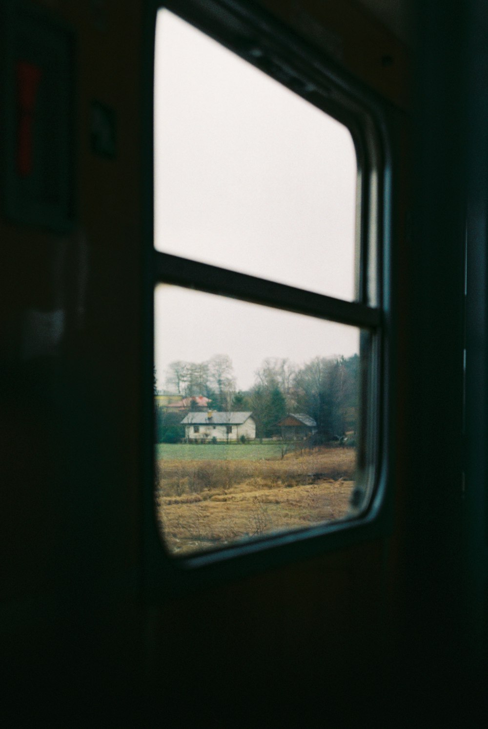 uma vista de uma fazenda de uma janela de trem