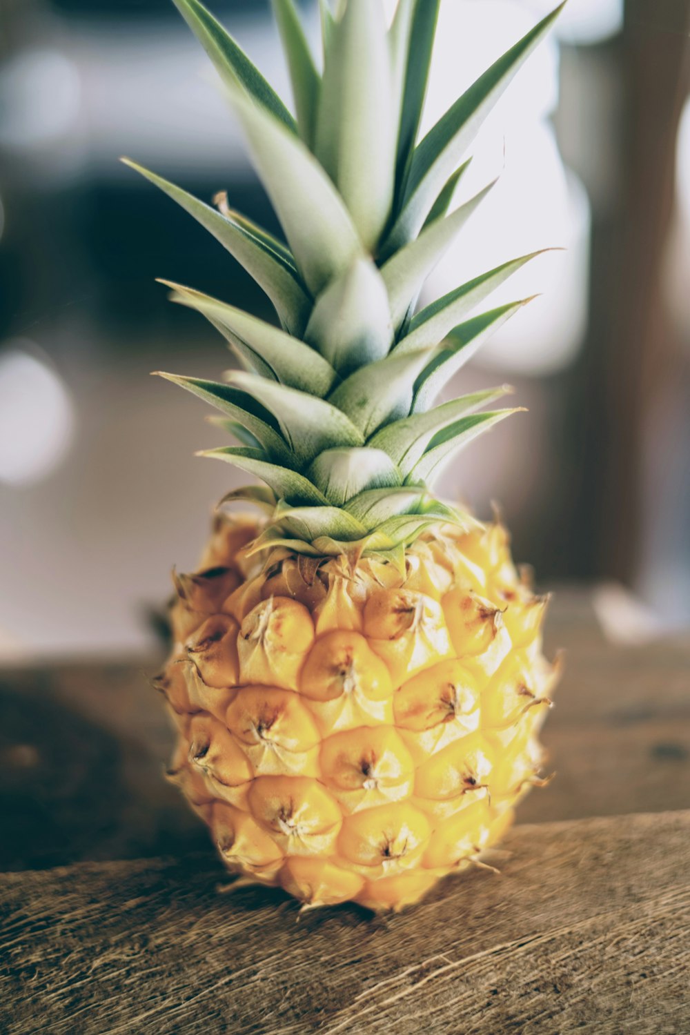 a pineapple sitting on top of a wooden table